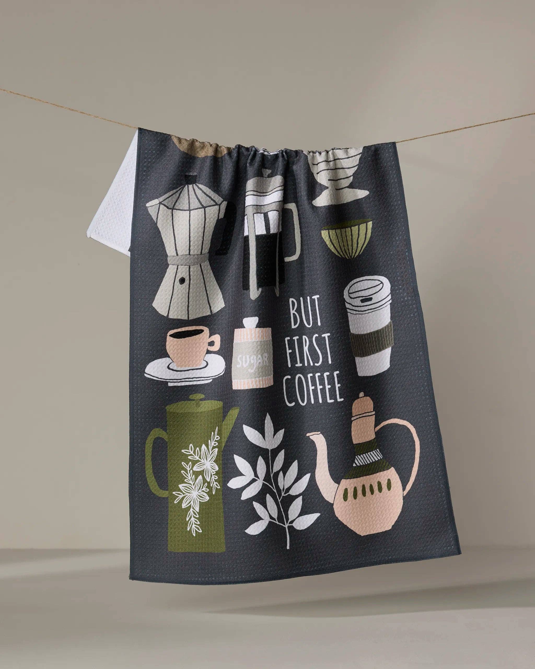 Dark gray coffee-themed tea towel with illustrated brewing tools and 'But First Coffee' text