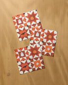 Three Halloween quilted-pattern dishcloths with ghosts, pumpkins, and bats in orange and white