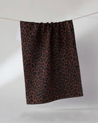 Brown and black leopard print kitchen tea towel hanging on a clothesline